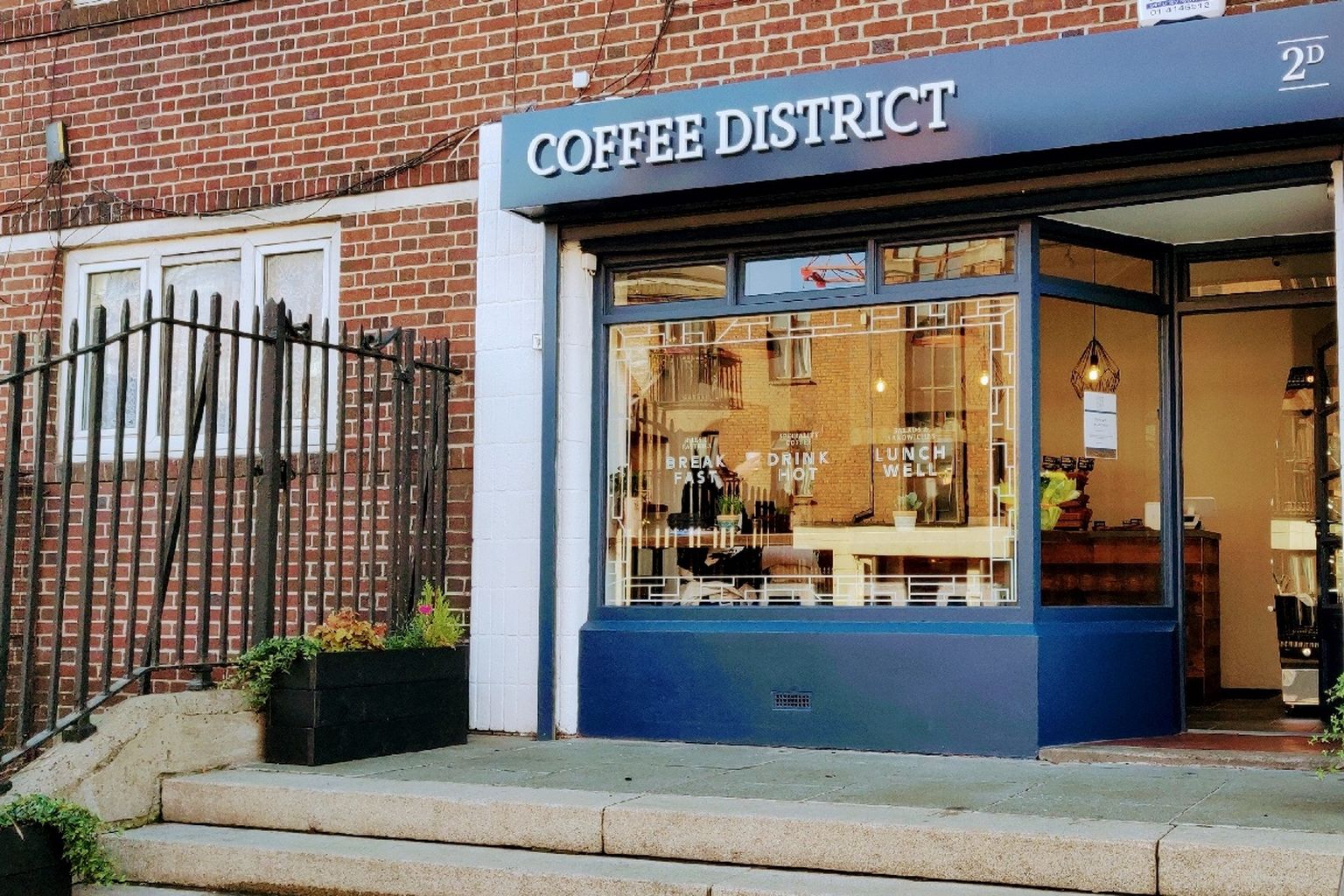 Coffee District's navy shopfront on James's Street, with white serif lettering and window signage reading Break Fast, Drink Hot, Lunch Well