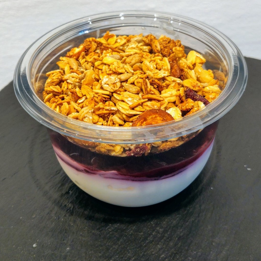 A granola, yoghurt and berry-compote pot on a slate board